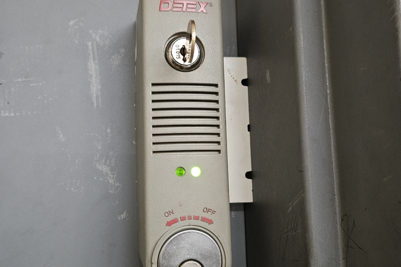 An electronic lock with a key override fitted to a gray steel cabinet door.