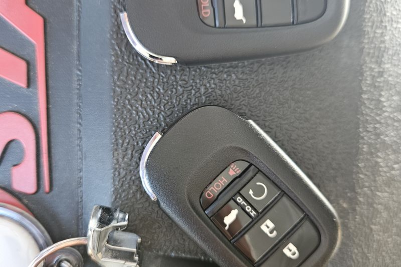 Two new Honda smart key fobs with freshly cut emergency blades, ready to be programmed to the car.