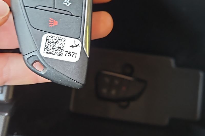 A newly programmed smart key held up inside the customer's car.