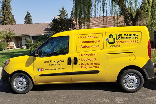 The Caring Locksmith's yellow service van parked on a residential street in Clovis, California.